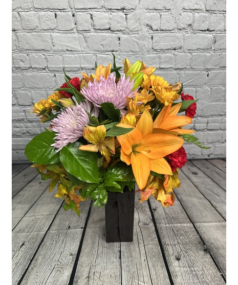 Asiatic lilies, alstroemeria, carnations, chrysanthemums and more in a clear glass vase. 