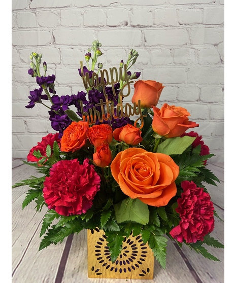 Purple, orange and pink flowers in a cube with Happy Birthday decoration.