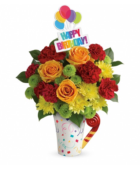 Orange and red flowers in a birthday-themed mug.
