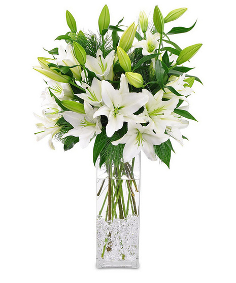 All-white bouquet of lilies in a tall rectangular vase accented with clear gems.